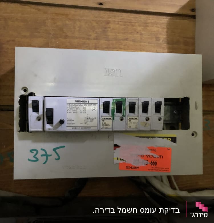 לוח חשמל עם מפסקים של סימנס על קיר עץ